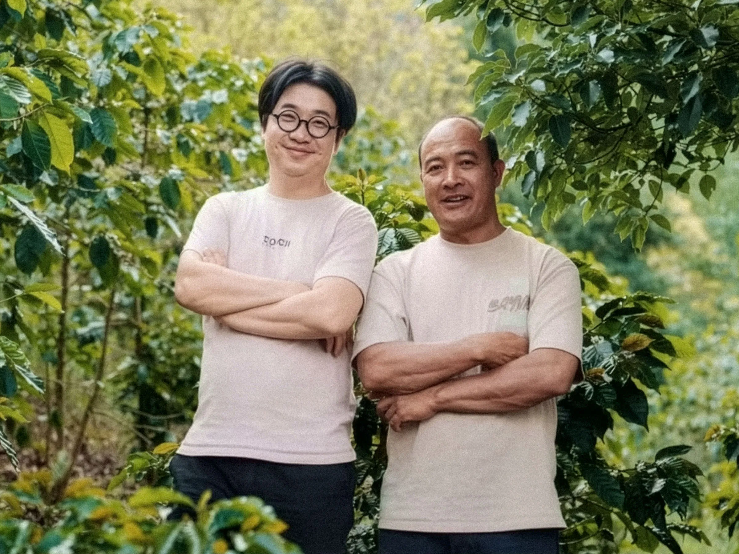 Portrait of the two Torch Estate producers in front of their coffee trees in Pu’er